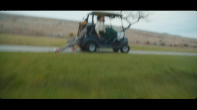 a man driving a golf cart down a road