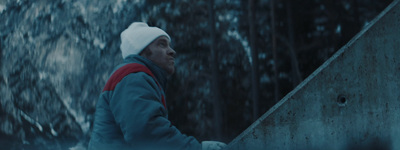 a man in a blue jacket and a white hat