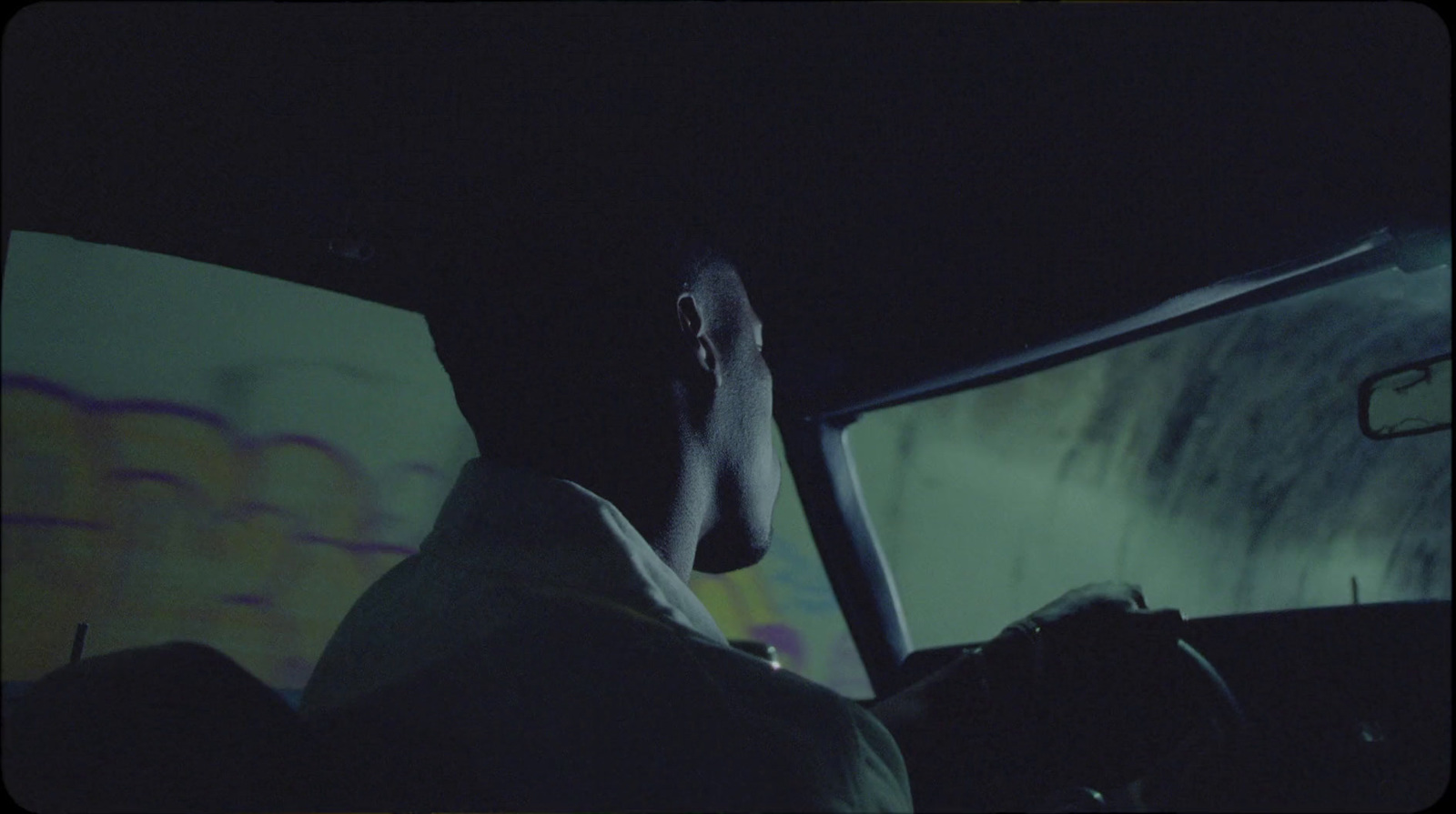 a man sitting in a car in the dark