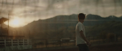 a man standing in front of a mountain at sunset