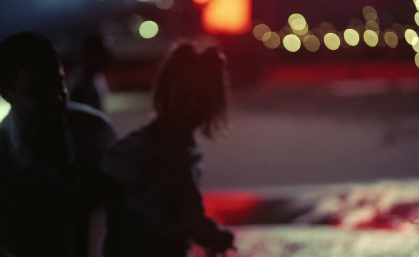 a blurry image of a man and a woman walking down a street