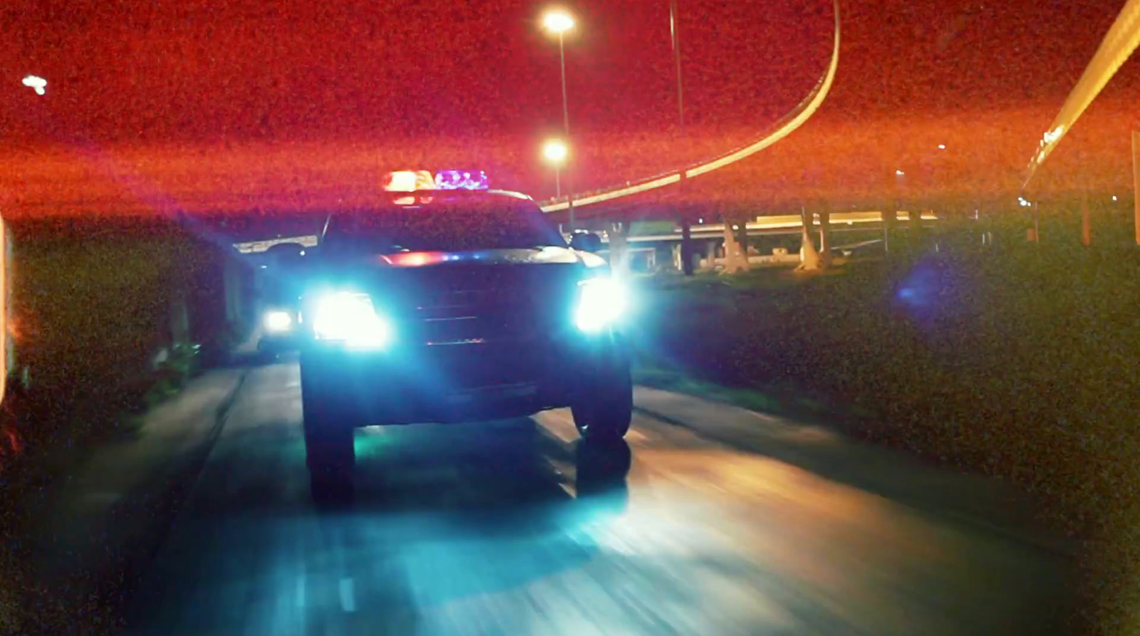 a police car driving down a street at night