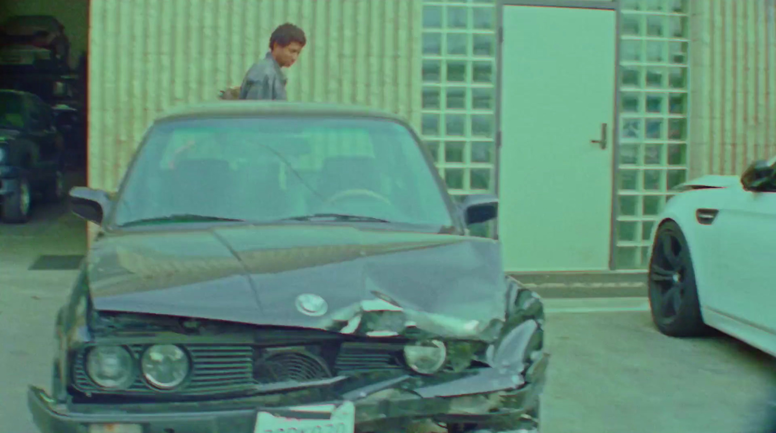 a man standing on top of a damaged car