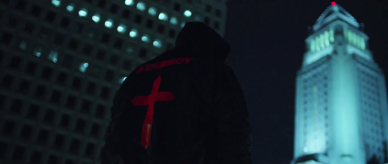 a person standing in front of a tall building with a cross on it