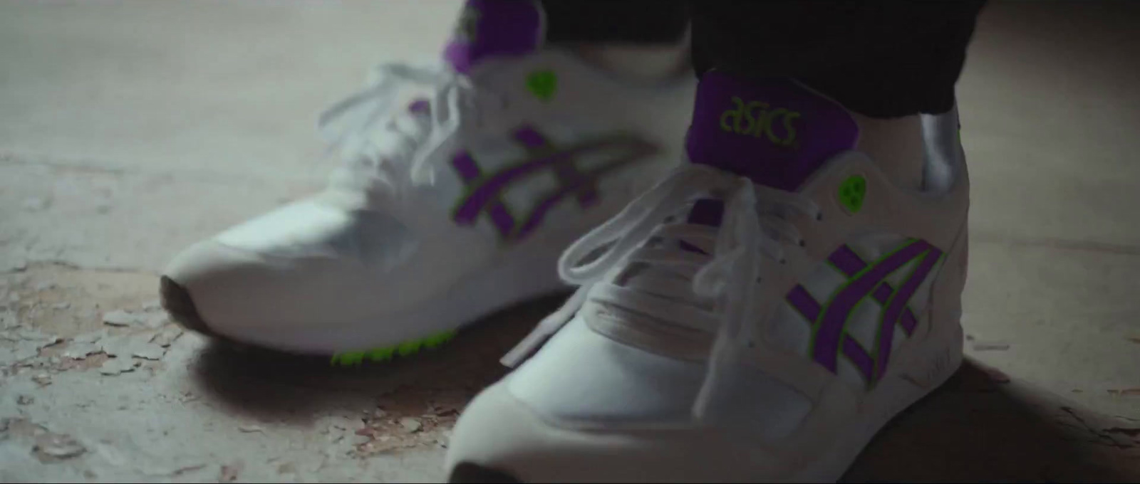 a pair of white shoes with purple and green accents