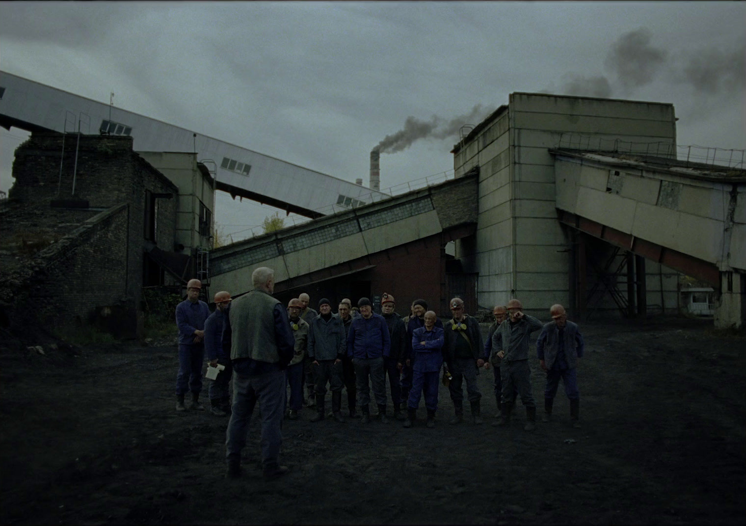 a group of people standing in front of a factory