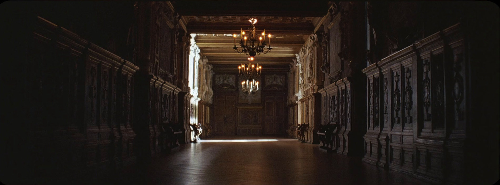 a long hallway with chandeliers hanging from the ceiling