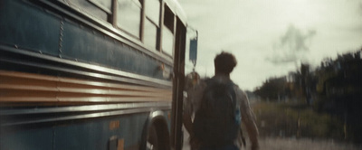 a blurry photo of a man walking next to a bus