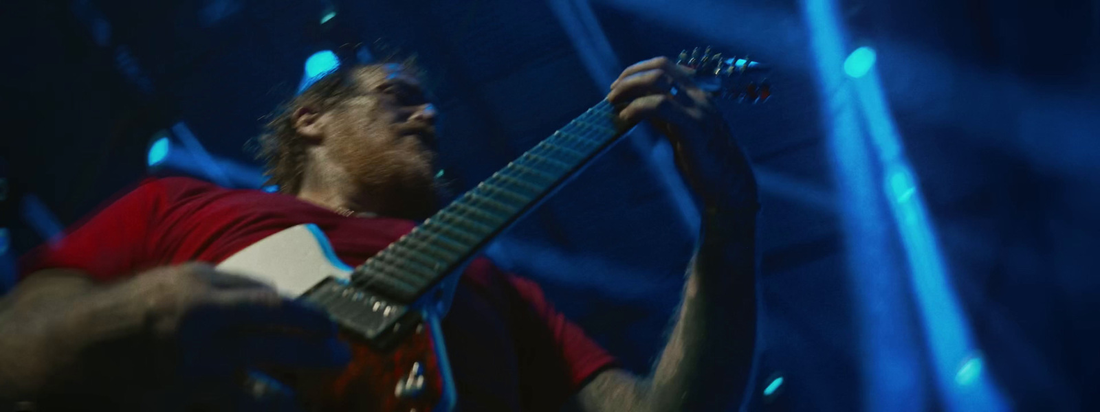 a man playing a guitar on stage at a concert