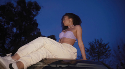 a woman sitting on the hood of a car