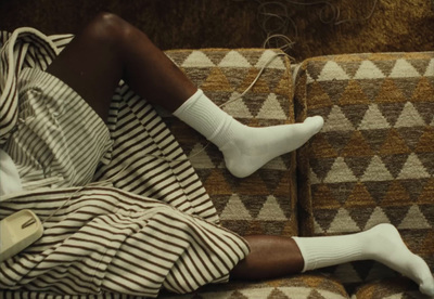 a woman laying on a couch wearing white socks