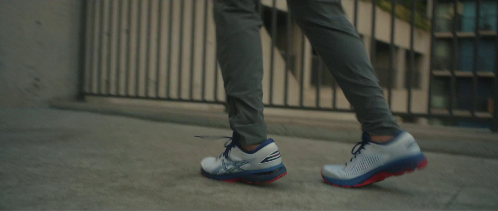 a person standing on a sidewalk with their foot on a skateboard