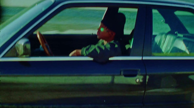 a boy sitting in a car with a book in his lap