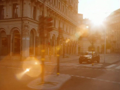 a car driving down a street next to tall buildings