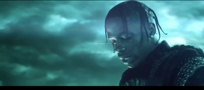 a man with dreadlocks standing in front of a cloudy sky