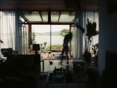 a woman standing in a living room next to a window