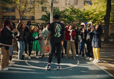 a group of people standing around a basketball court