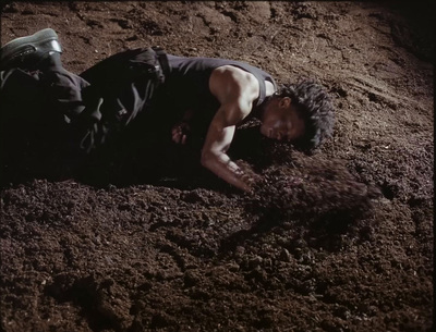 a man laying on the ground covered in dirt