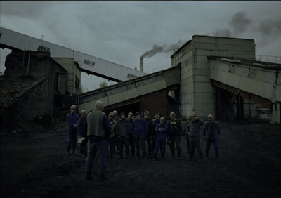 a group of people standing in front of a factory