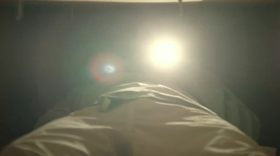 a person laying in a bed under a light