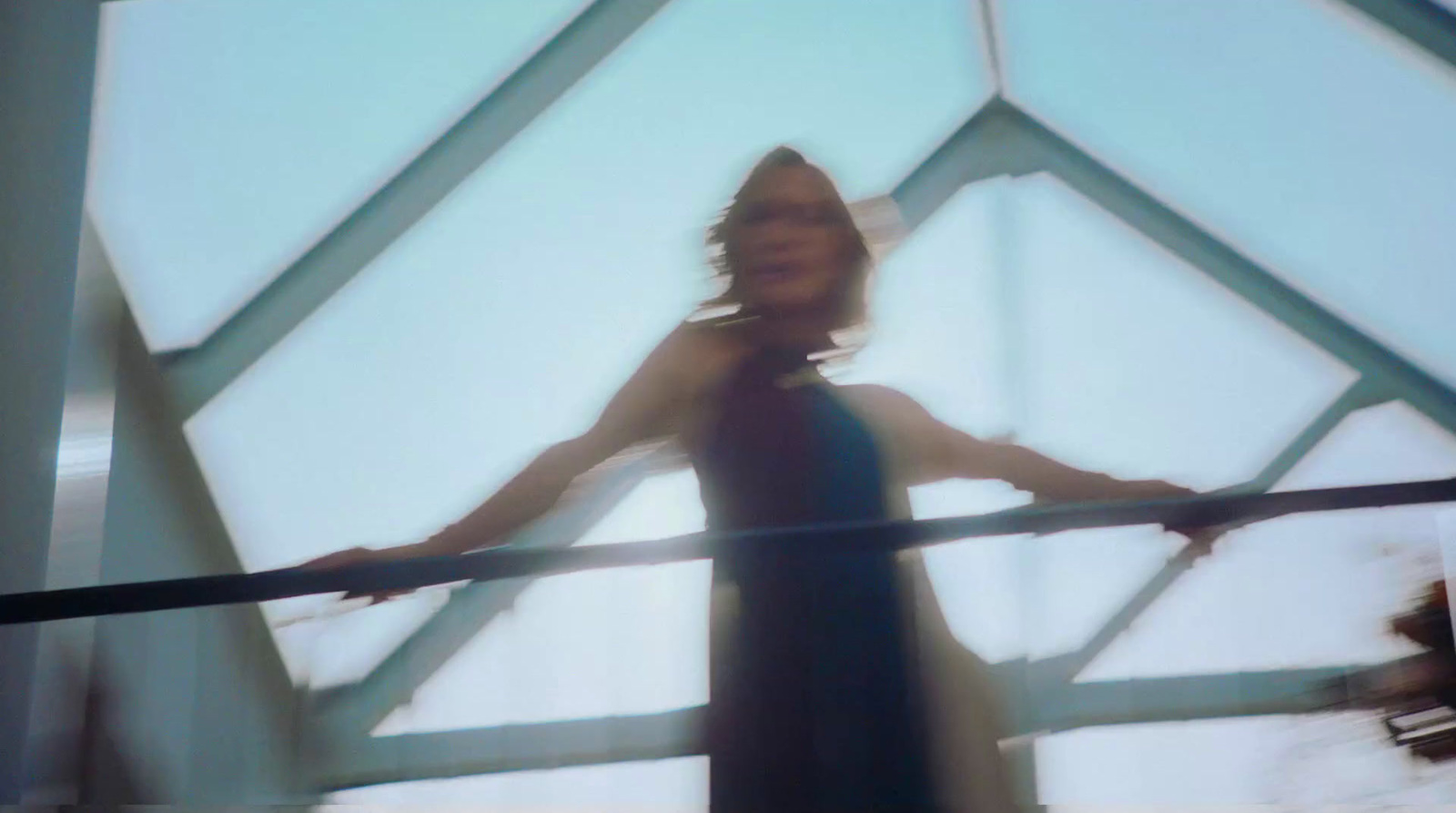 a woman in a black dress standing on a bridge