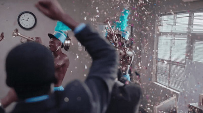 a man in a party hat throwing confetti into the air