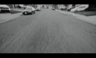 a black and white photo of cars driving down a street