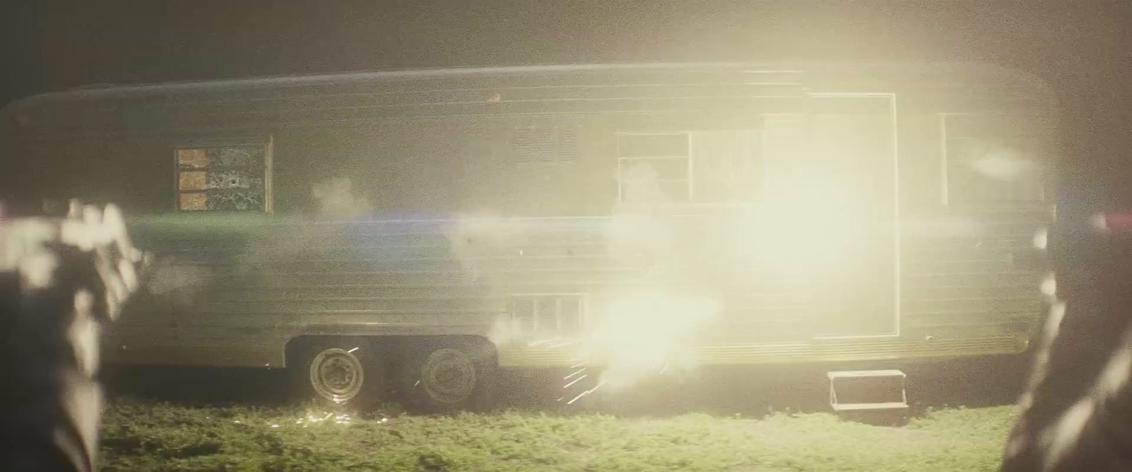 a person standing in front of a trailer in the grass