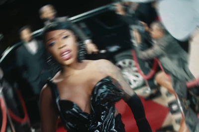 a woman in a black dress walking down a red carpet