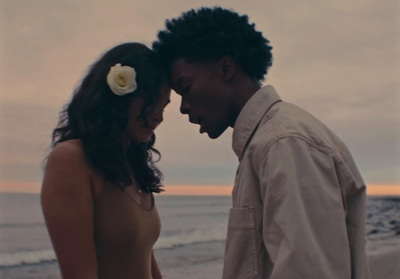 a man and a woman standing next to each other on a beach