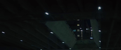 a man riding a skateboard under a bridge at night