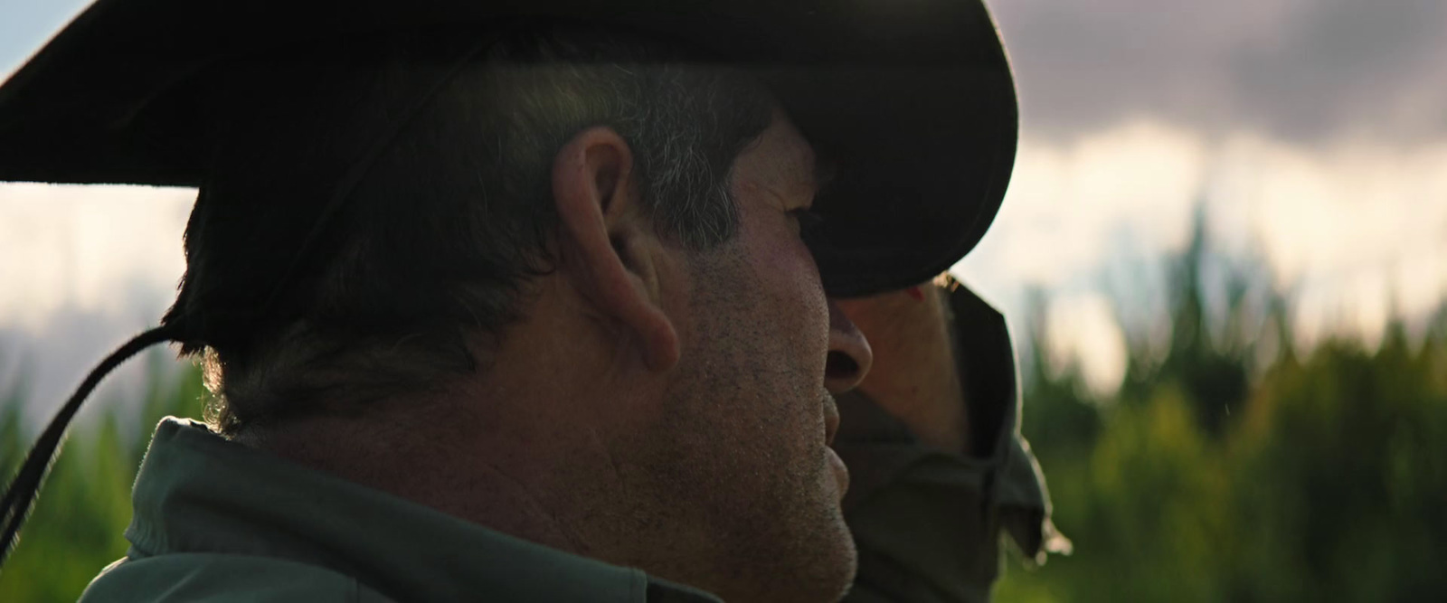 a man wearing a hat and a green jacket