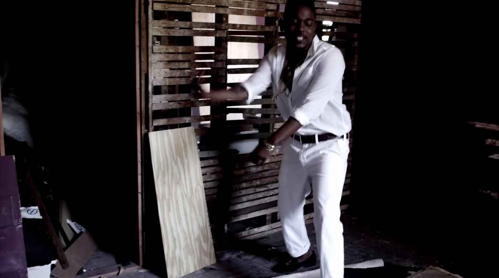 a man standing next to a wooden wall