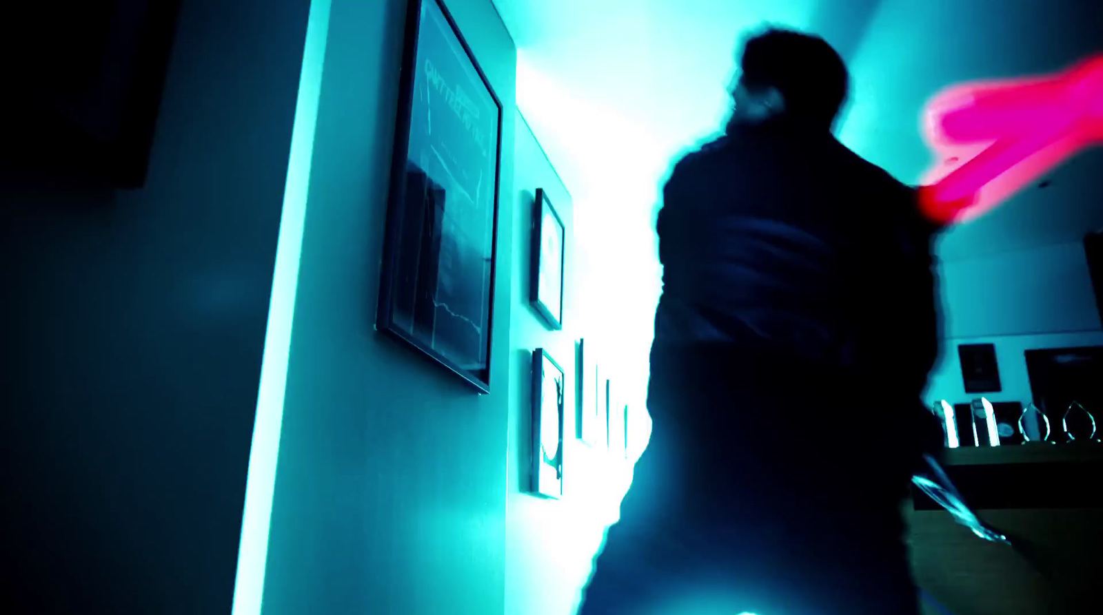 a man walking down a hallway in a dark room