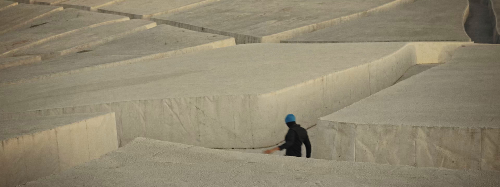 a person in a blue hat standing in a concrete area