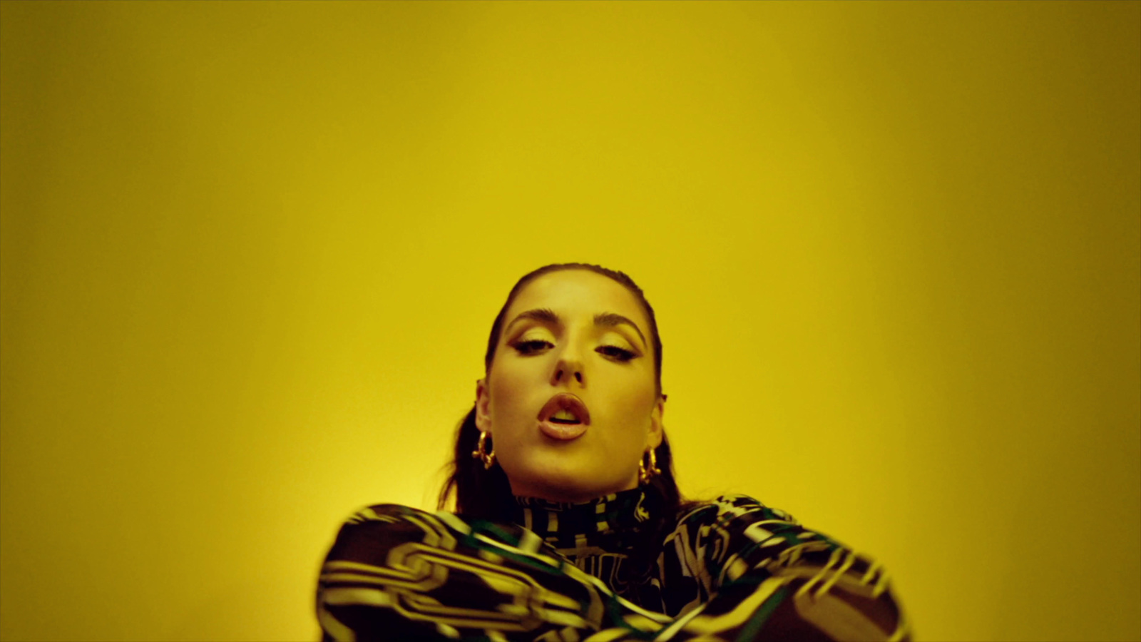 a woman in a black and white shirt and a yellow background