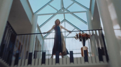 a woman in a blue dress standing on a balcony