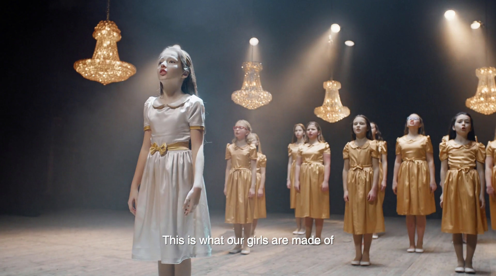 a group of women standing in front of chandeliers