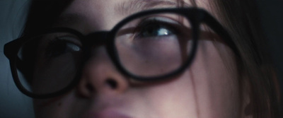 a close up of a woman's face with a pair of glasses on her