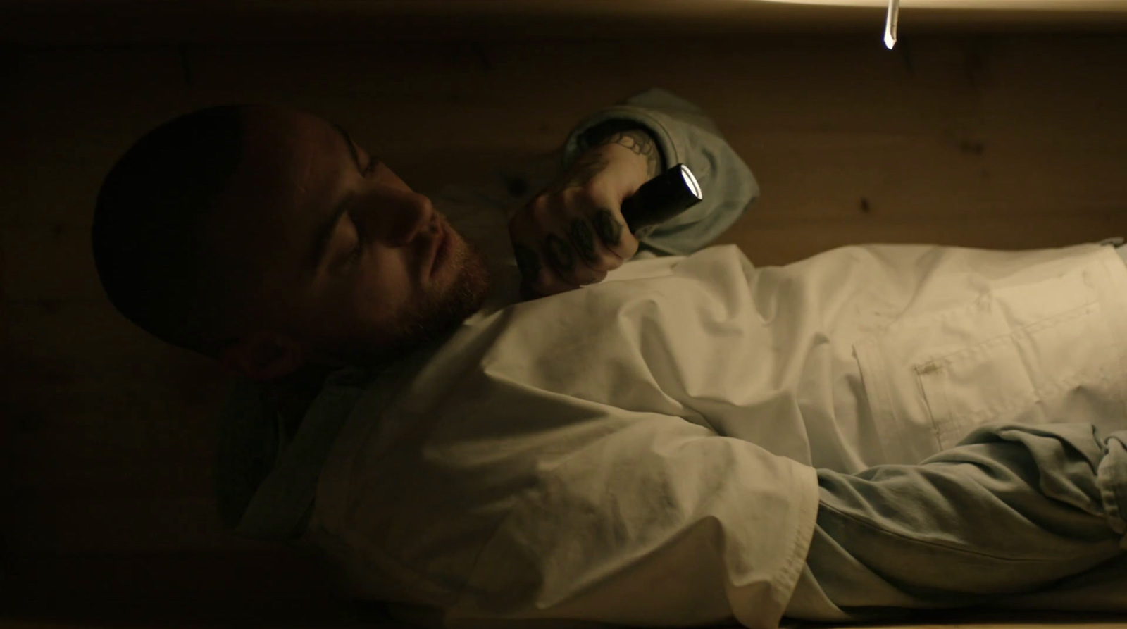 a man laying on a bed with a cell phone in his hand