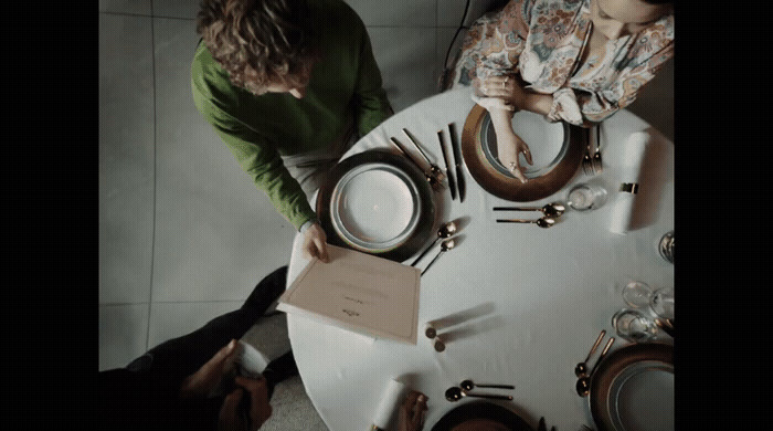 two people sitting at a table with plates and silverware