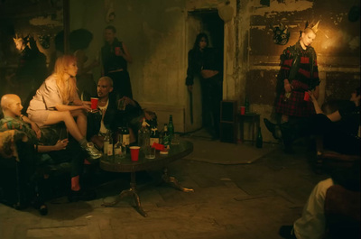 a group of people sitting around a table with bottles of wine