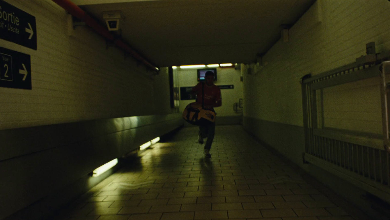 a person walking down a hallway with a guitar