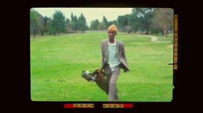 a man walking across a lush green field