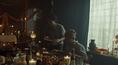 a couple of men sitting at a table in front of candles