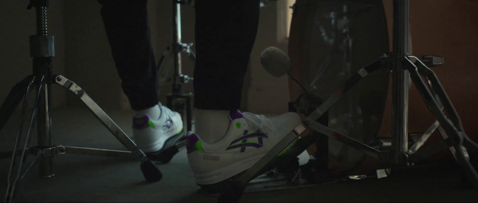 a pair of feet standing on a tripod in a dark room