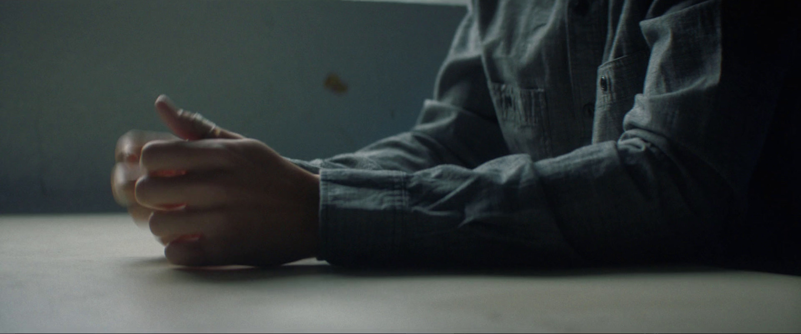 a person sitting at a table using a cell phone