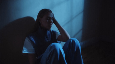 a woman sitting on the floor in a dark room