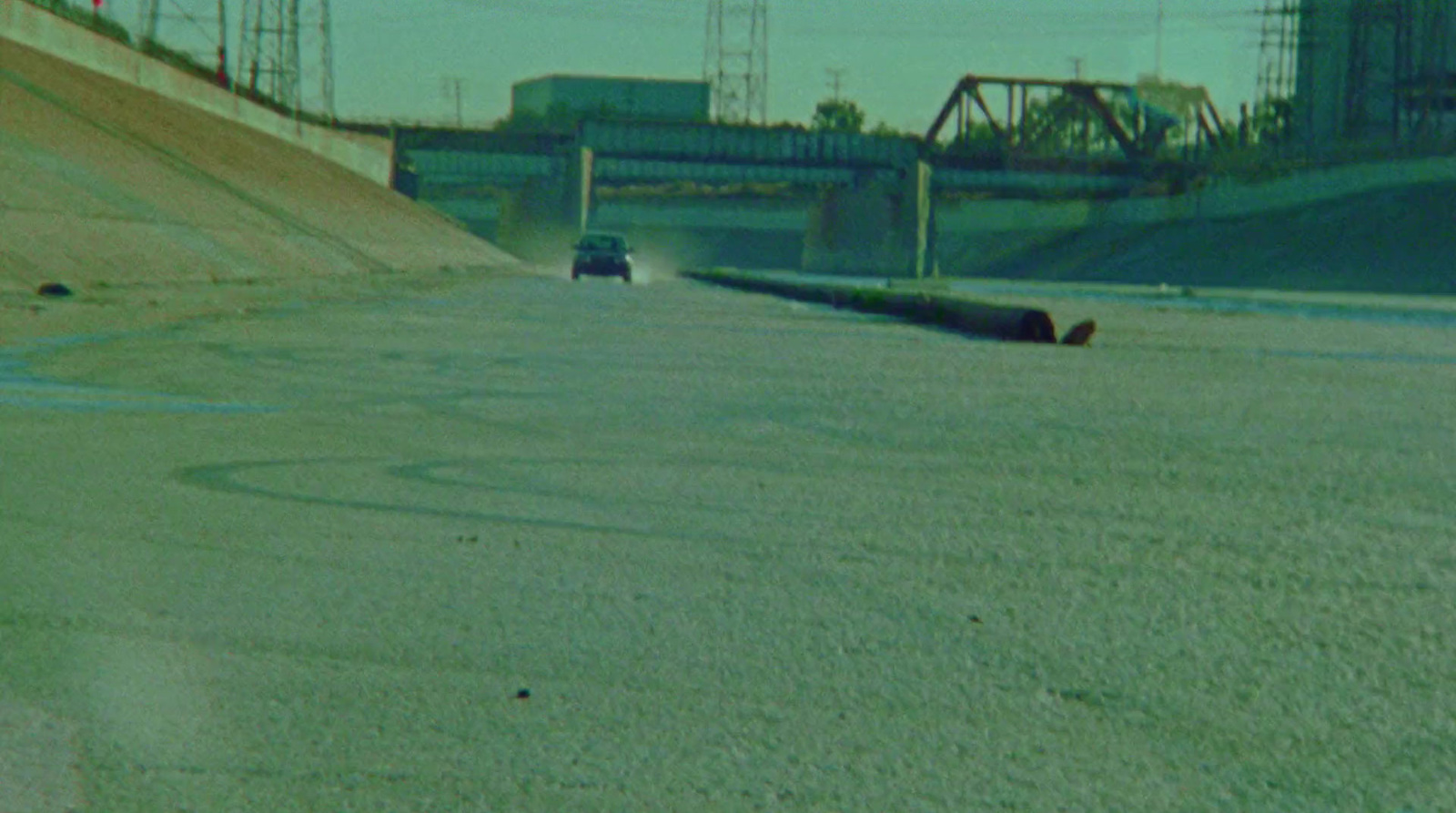 a car driving down a road next to a bridge