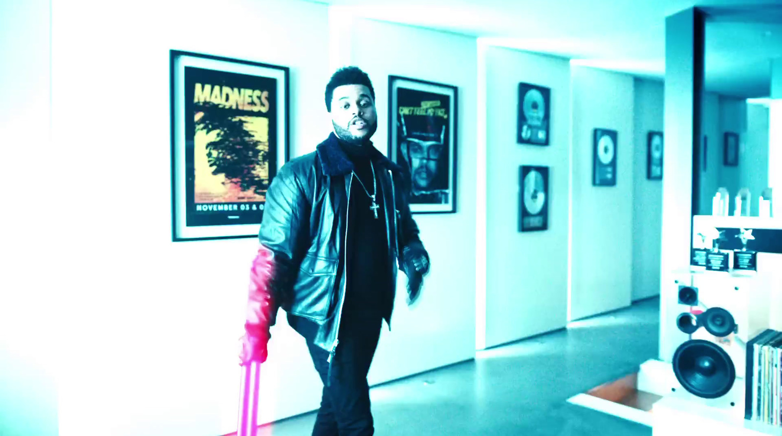 a man walking down a hallway holding a pink umbrella